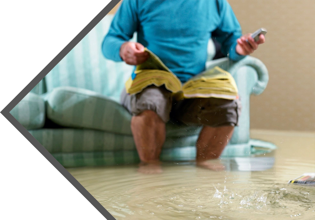 A man sitting on the floor holding a remote control.