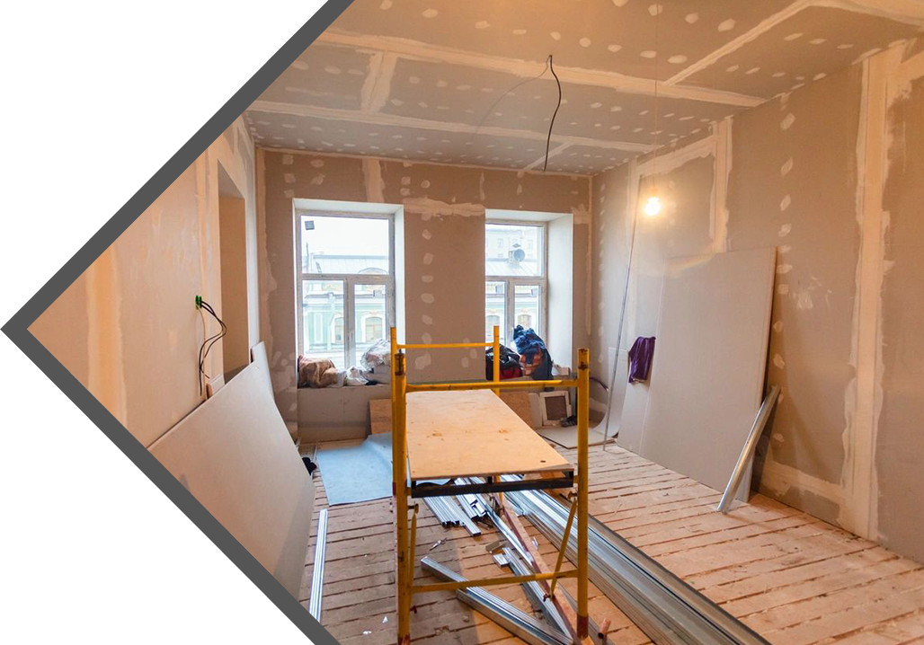 A room being remodeled with scaffolding and sheetrock.