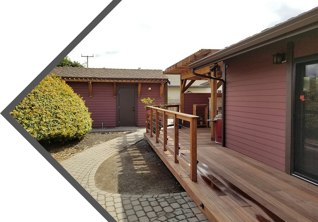 A wooden walkway leading to a building with a porch.