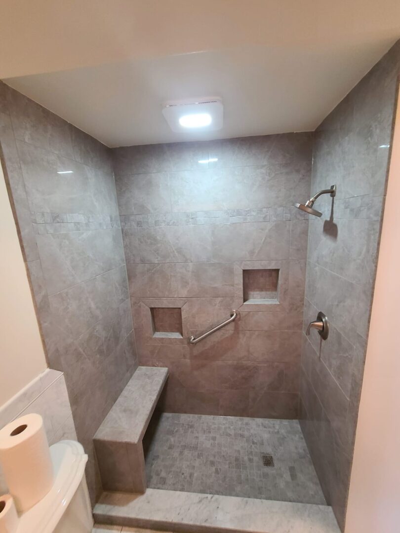 A bathroom with a bench and tiled walls.